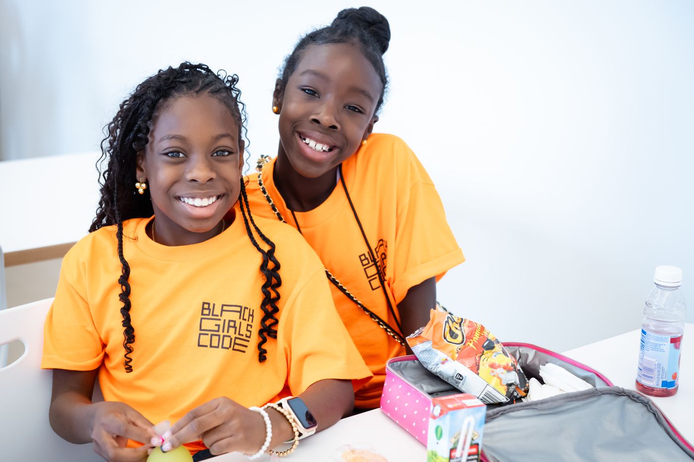 Two smiling students at lunch